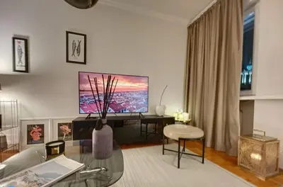 a living room with a large tv and a vase at Superbe last floor next Presidency in Sofia