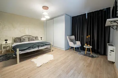 a bedroom with a bed and a chair at Планинска вила АЛТЕА in Mostowo