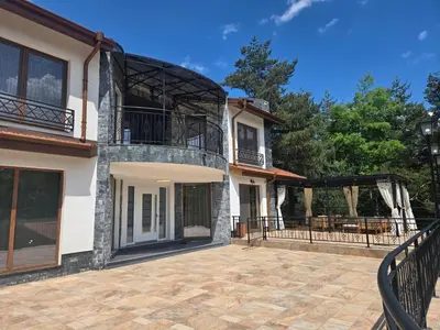 a house with a balcony and a patio at Планинска вила АЛТЕА in Mostowo