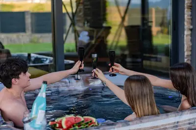 a group of people holding glasses of wine in a hot tub at Hypnotic Thermal Villas with private SPA in Banya