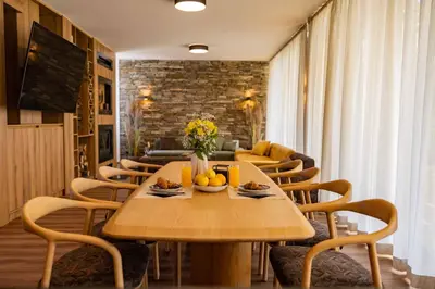 a dining room with a wooden table and chairs at Hypnotic Thermal Villas with private SPA in Banya
