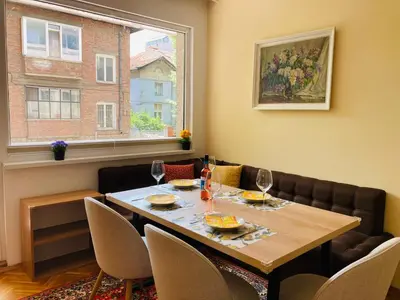 a dining room with a table and chairs and a window at Central Vintage Apartment for 4 Guests & Private Parking in Plovdiv
