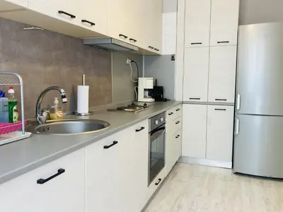a kitchen with white cabinets and a sink and a refrigerator at Central Vintage Apartment for 4 Guests & Private Parking in Plovdiv