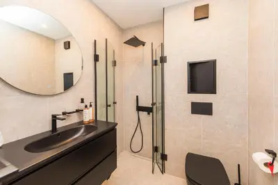 a bathroom with a sink and a mirror at Eleve Residences - Obsidian Studios in Sofia