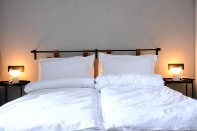 two white pillows on a bed with two lamps at Eleve Residences - Obsidian Studios in Sofia