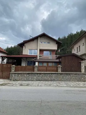 a house with a wooden fence in front of a street at Къща за гости Хриси in Mala Tsŭrkva