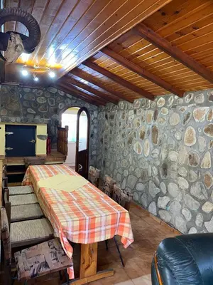 a room with a table and a stone wall at Къща за гости Хриси in Mala Tsŭrkva