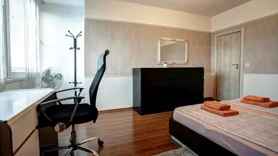 a room with a bed with a desk and a chair at River Apartment in Sofia