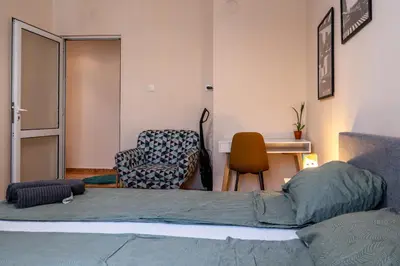 a bedroom with a bed and a chair and a desk at Teo's Cozy Top Central Apartment in Sofia