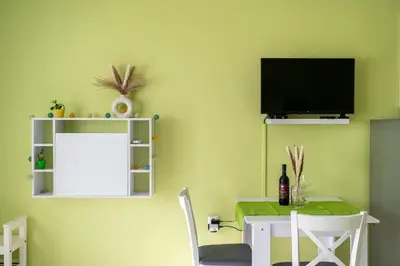 a dining room with a table and a tv on a wall at Skyline Studio in Sofia