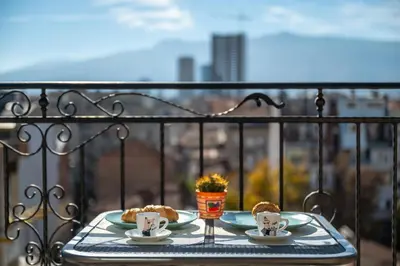 a table with two plates of food on a balcony at Skyline Studio in Sofia