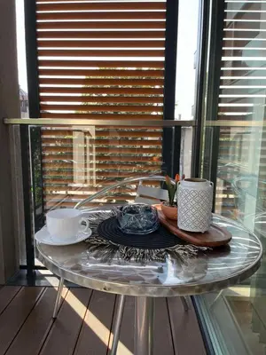a glass table with two cups and a plate on it at Апартамент в сърцето на ПЛОВДИВ in Plovdiv