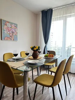 a dining room with a table and chairs with wine glasses at Rea Flora - Cozy Stay With Free Parking in Sofia