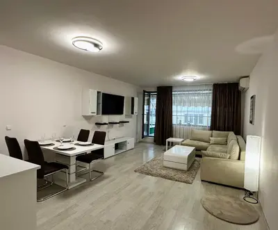 a living room with a kitchen and a dining room at Apartment Garden - two large terraces with hanging chairs and sunset view in Sofia