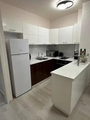 a kitchen with white cabinets and a white refrigerator at Apartment Garden - two large terraces with hanging chairs and sunset view in Sofia