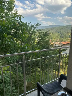a balcony with a chair and a view at Къща за гости Sunrise - Батак in Batak