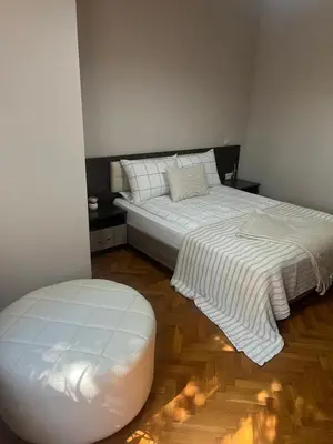 a bedroom with two beds and a ottoman at Dunav 11 in Sofia