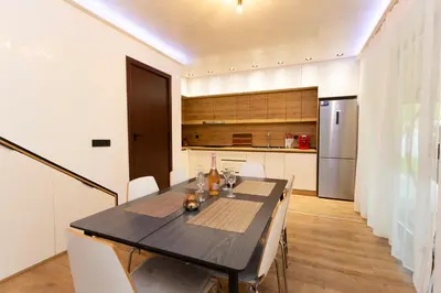 a kitchen and dining room with a table and chairs at Forest Nest in Krayni Dol