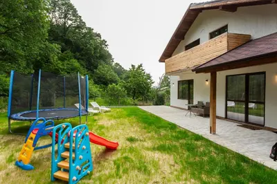 a backyard with a trampoline and playground equipment at Forest Nest in Krayni Dol