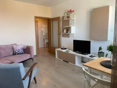 a living room with a couch and a television at Premium High Rise, Gorgeous City Views in Plovdiv