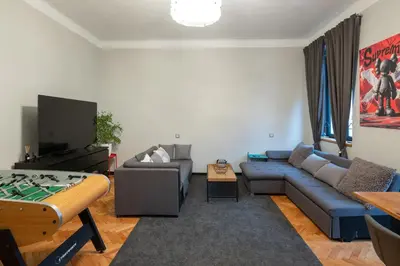 a living room with a blue couch and a pool table at Urban Oasis Heaven in Sofia