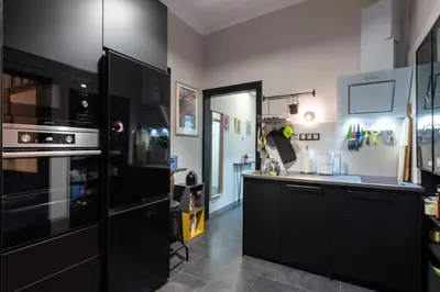 a kitchen with black cabinets and a black refrigerator at Urban Oasis Heaven in Sofia