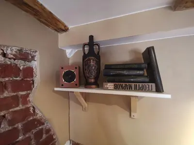 a shelf with books and a clock and a speaker at D1 LOFT-Top center with free parking in Sofia