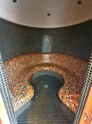 a bathroom with a pool of water in a tile floor at Trinity Apartment & Pool with Spa Near Center in Bansko