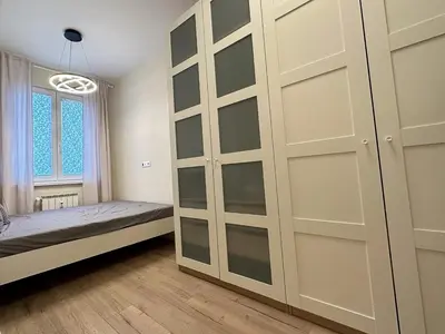 a bedroom with a closet with glass doors at Park Apartment in Sofia
