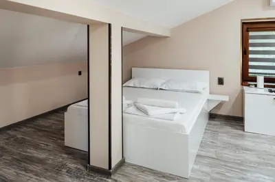a bedroom with a white bed and a mirror at Hrisi&Kris in Sapareva Banya