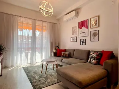 a living room with a couch and a large window at Central 53 Vitosha View 2BD Apartment in Sofia