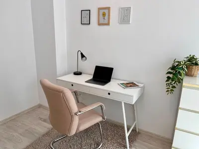 a desk with a chair and a laptop on it at Central 53 Vitosha View 2BD Apartment in Sofia