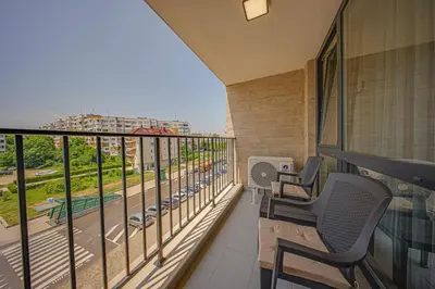 a balcony with two chairs and a view of a street at Brand New Vitosha View Apartment - Free Parking - Metro Access in Sofia
