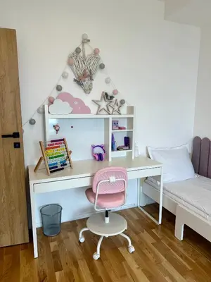 a desk with a pink chair and a bed at The Skyline Residence Sofia in Sofia