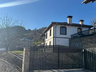 a white house with a fence in front of it at Guest House in Rhodope Mountains in Rudozem