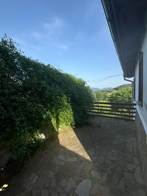 a hedge next to a building with a fence at Guest House in Rhodope Mountains in Rudozem