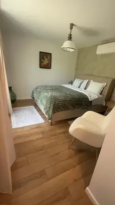 a bedroom with a bed and a chair at Villa Green House in Tscherweni Breg