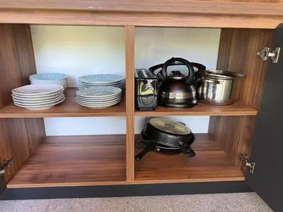 a wooden cabinet with dishes and a tea pot on it at Villa Green House in Tscherweni Breg