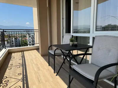 a balcony with a table and chairs and a view at 1BR Apartment with Panoramic View Balcony and Designated Parking Space in Plovdiv