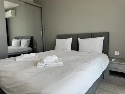 a white bed with towels on top of it at 1BR Apartment with Panoramic View Balcony and Designated Parking Space in Plovdiv