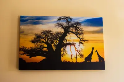 a painting of two giraffes standing next to a tree at SimplyComfy in Plovdiv