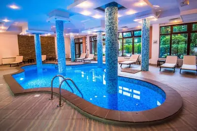 a pool in a hotel lobby with chairs and tables at Orbilux - Cozy Studio in Bansko by Flat Mаnager in Bansko