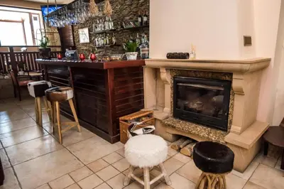 a room with a fireplace and a bar with stools at Orbilux - Cozy Studio in Bansko by Flat Mаnager in Bansko