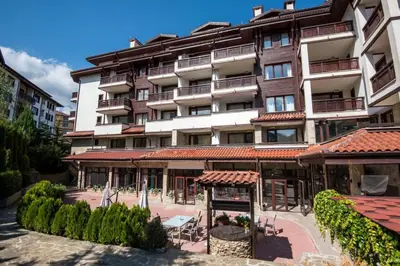 a large apartment building with tables and chairs in front of it at Orbilux - Cozy Studio in Bansko by Flat Mаnager in Bansko