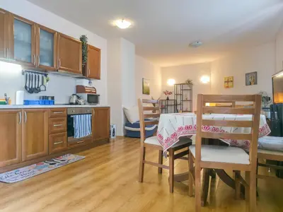 a kitchen and dining room with a table and chairs at Charming 1BD Flat at Edelweiss Inn, Bansko by Flat Mаnager in Bansko