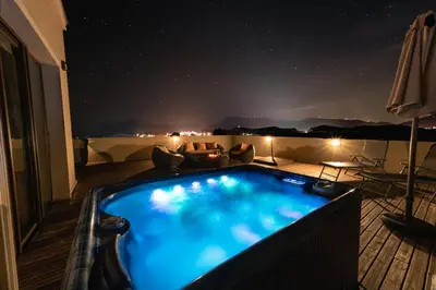 a hot tub on top of a balcony at night at Mantar Spa Hotel in Marikostinovo