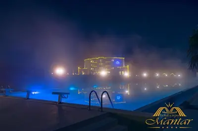 a large building in the water at night at Mantar Spa Hotel in Marikostinovo