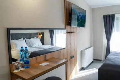 a hotel room with a bed with bottles on a counter at Villa Veranda in Smolyan