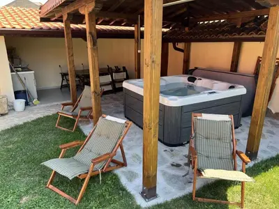 two chairs and a hot tub under a gazebo at Villa Geshevi in Hisarya