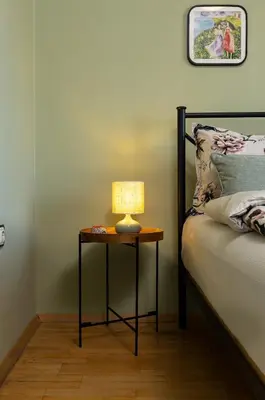 a table with a lamp on it next to a bed at Spacious 2BR Apt Kremena 10 minutes walk to Center in Plovdiv